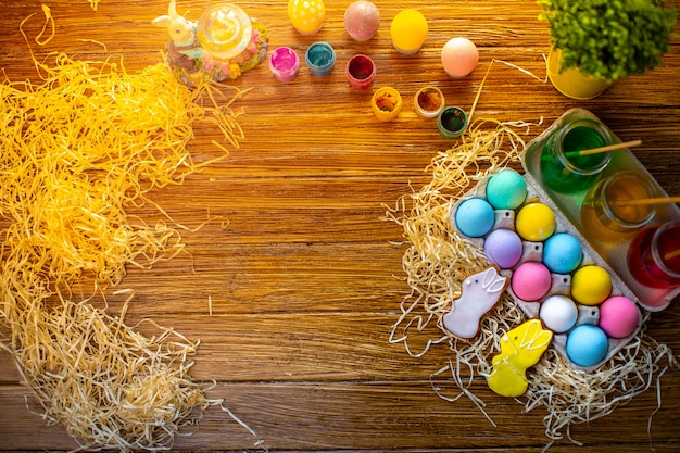 Joyeuses Pâques. Fond avec des oeufs colorés dans le panier. Décoration de table pour les vacances. Vue de dessus.