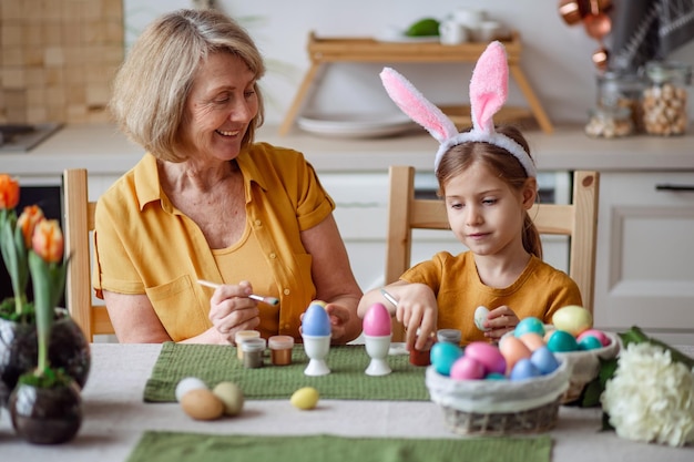 Photo joyeuses pâques grand-mère âgée de la famille et petite-fille avec des oreilles de lapin