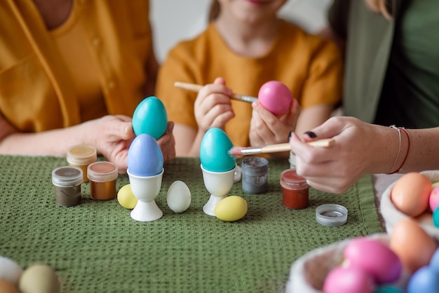 Joyeuses pâques mains agrandi grand-mère et mère avec des oeufs de peinture de petite fille