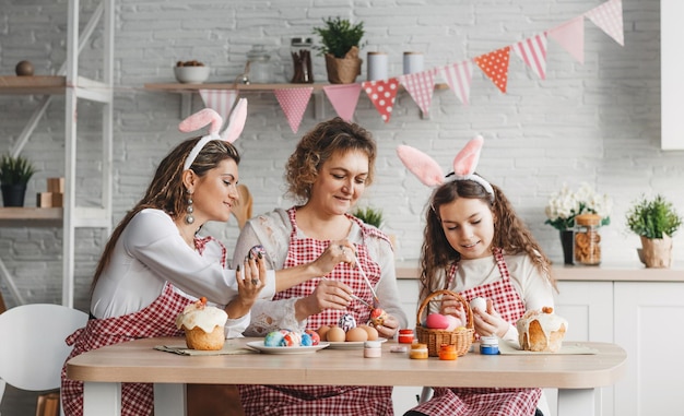Joyeuses Pâques Mère et filles dessinent des oeufs de Pâques Une famille heureuse se prépare pour Pâques