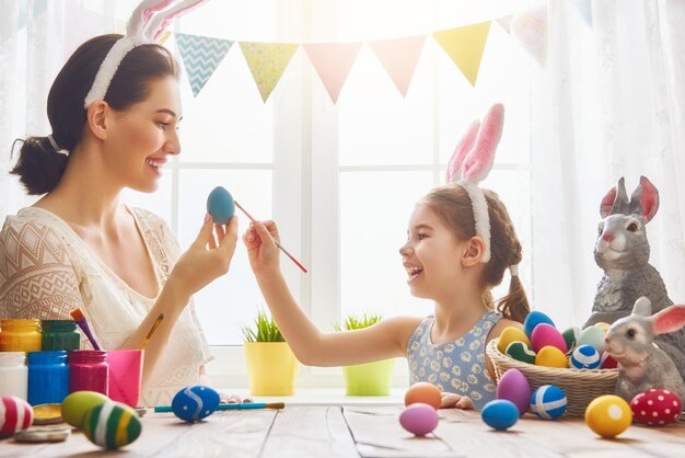 Joyeuses pâques Une mère et sa fille peignant des oeufs de Pâques Famille heureuse se préparant pour Pâques