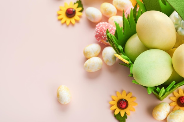 Joyeuses Pâques Oeufs de Pâques et lapin dans un panier vert sur fond rose avec des roses blanches et jaunes Printemps Joyeuses Pâques carte de vacances Fond de Pâques avec espace de copie Vue de dessus