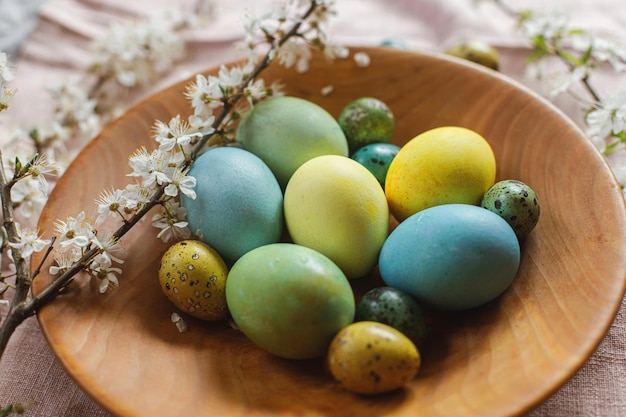 Joyeuses Pâques Oeufs de Pâques teints naturels élégants sur une plaque en bois avec des fleurs de printemps sur une table rustique Cuisine de Pâques traditionnelle Nature morte de Pâques rustique