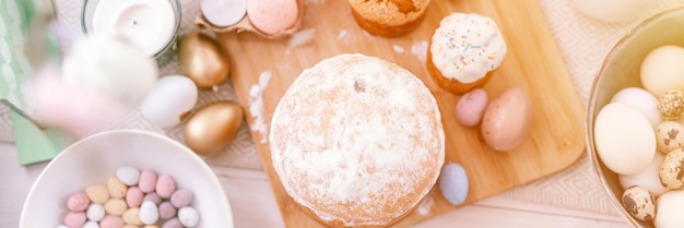 Joyeuses pâques et vacances de printemps temps décor de table festif décor traditionnel dîner nourriture oeufs de pâques et gâteaux cuits au four sur la table à la maison pâle pop pastel bleu et rose couleur vue de dessus bannière flare