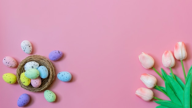 Joyeuses Pâques, vue de dessus des oeufs de Pâques et fleur de tulipe sur fond de couleur rose