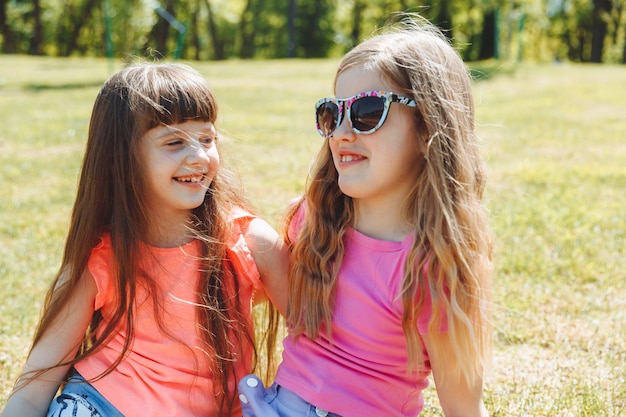 Joyeuses petites copines s'amusent dans le parc pendant les vacances d'été