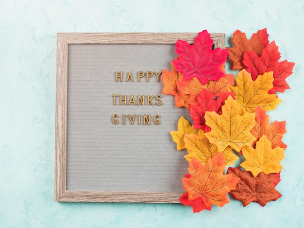 Joyeuses salutations de thanksgiving sur le tableau des lettres avec des feuilles rouges et oranges d'automne