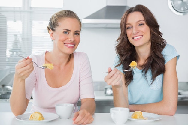 Joyeux amis, manger un gâteau et prendre un café