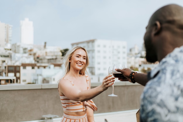 Photo joyeux amis portant un toast à une fête sur le toit