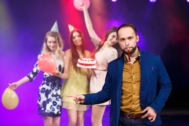 Joyeux anniversaire! Groupe d'amis souriants réunis avec un gâteau.