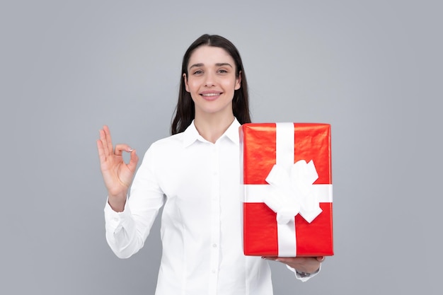 Joyeux anniversaire Woman holding gift box avec ruban Studio portrait sur fond gris