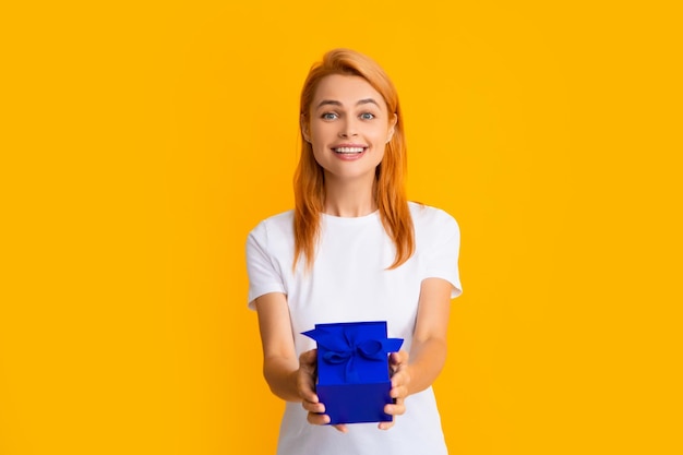 Joyeux anniversaire Woman holding gift box with ribbon Studio portrait sur fond jaune