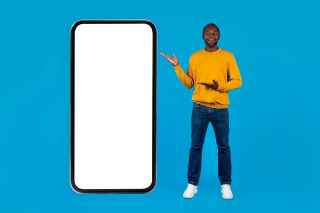 Joyeux black pointant sur une grande maquette de téléphone portable