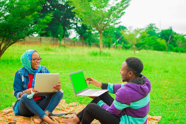 Joyeux bons amis africains s'amusant à l'extérieur avec un téléphone intelligent mobile - Concept d'amitié avec un garçon et une fille lors d'un voyage de vacances de printemps - Mode de vie masculin et féminin moderne