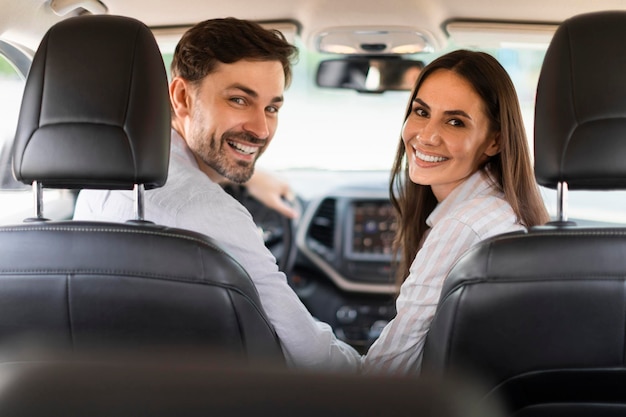 De joyeux conjoints du millénaire appréciant de voyager ensemble en voiture