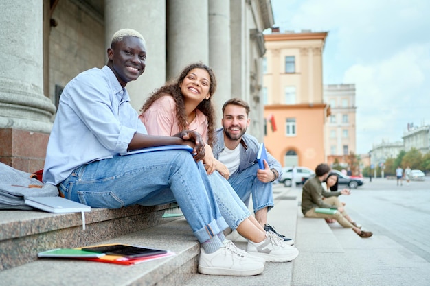 Joyeux couple d'étudiants assis sur les marches