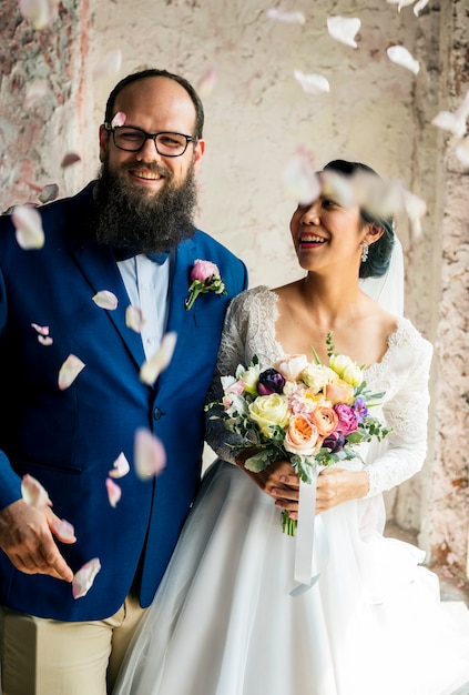 Joyeux Couple de jeunes mariés lançant une cérémonie de mariage de confettis