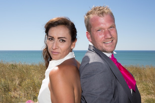 Joyeux couple marié debout sur la plage