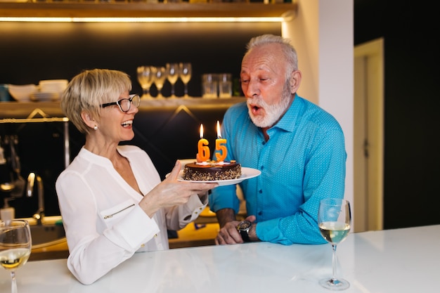 Joyeux couple de personnes âgées célébrant leur anniversaire ensemble.