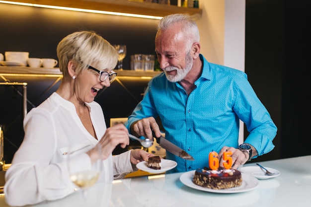 Joyeux couple de personnes âgées célébrant leur anniversaire ensemble.