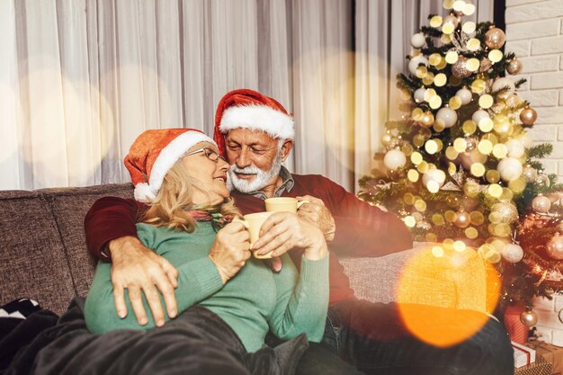 Joyeux couple de personnes âgées célébrant le nouvel an à leur domicile.