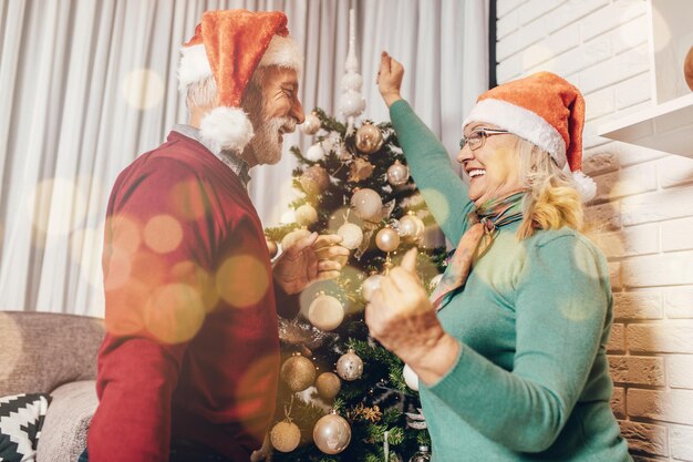 Joyeux couple de personnes âgées célébrant le nouvel an à leur domicile.