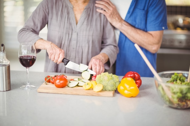 Joyeux couple de personnes âgées préparant une salade