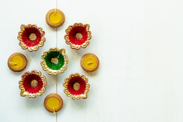 Joyeux Diwali, lampes Clay Diya allumées lors de la fête du festival hindou de Dipavali. Lampe à huile traditionnelle colorée diya sur bois blanc