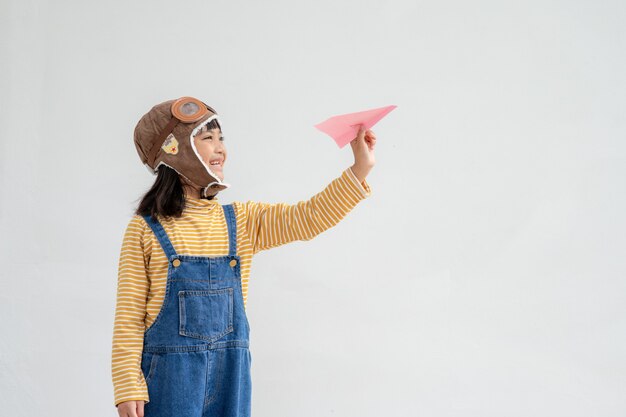 Joyeux enfant asiatique jouant avec un avion en papier