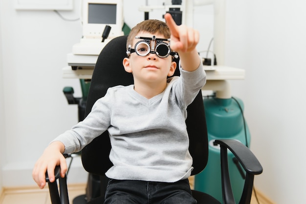 Photo joyeux enfant garçon dans des verres vérifie la vision des yeux ophtalmologiste pédiatrique.