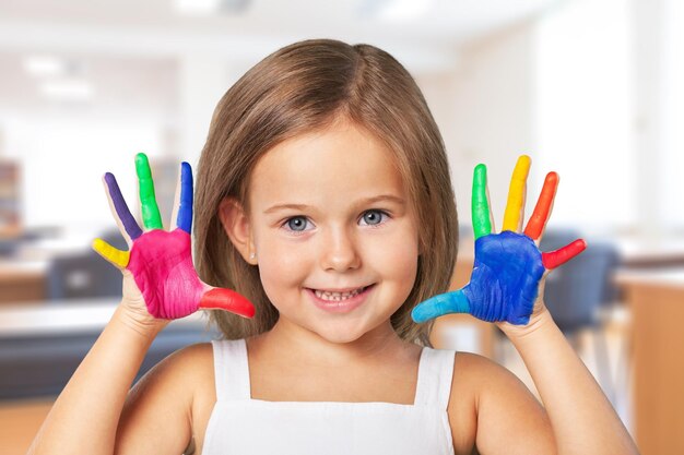 Joyeux enfant jouant avec de la peinture dans ses doigts.
