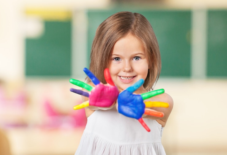 Photo joyeux enfant jouant avec des peintures dans ses doigts.