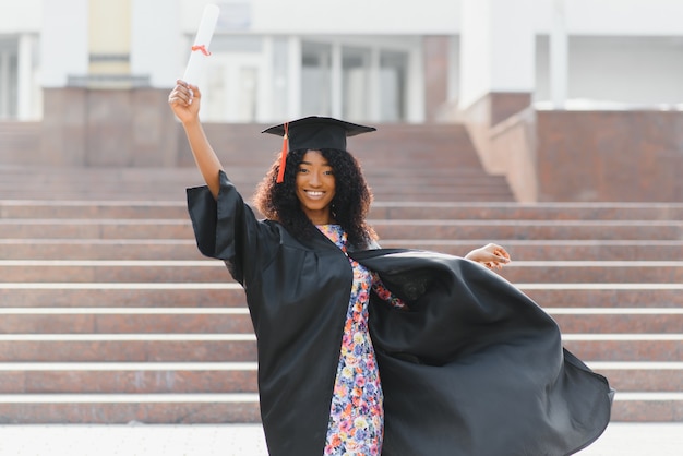 Joyeux étudiant diplômé afro-américain avec diplôme à la main