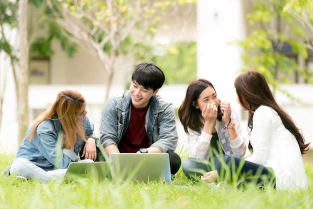 Joyeux étudiants universitaires avec ordinateur portable dans le groupe d&#39;étudiants