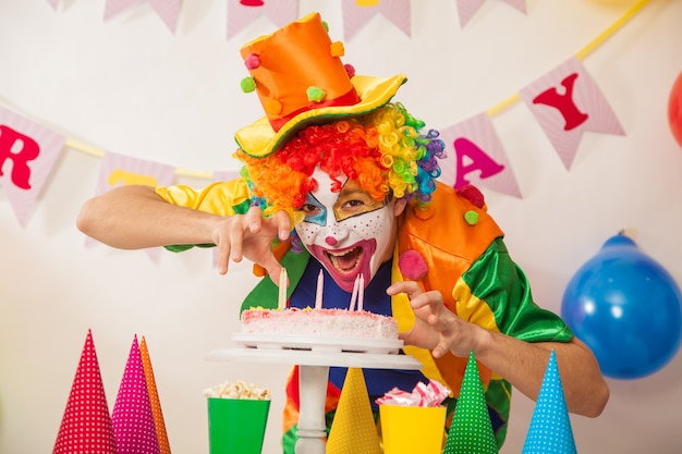Joyeux garçon clown en vacances avec un gâteau