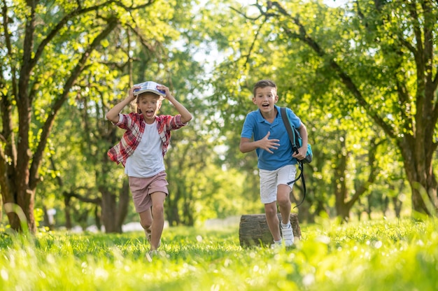 Joyeux garçon et fille qui court dans le parc