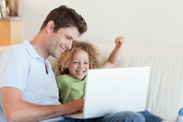 Joyeux garçon et son père à l&#39;aide d&#39;un ordinateur portable