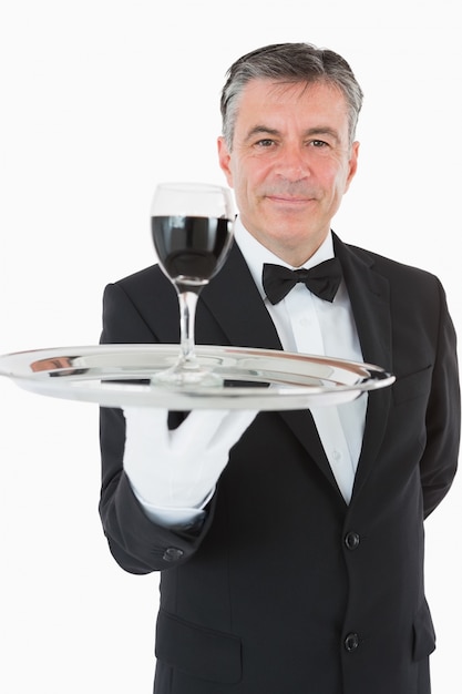 Photo joyeux garçon tenant un verre de vin sur un plateau d'argent