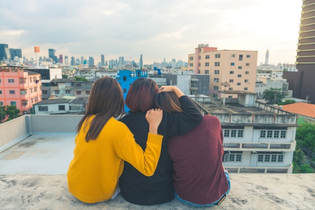 Joyeux groupe d&#39;amis asia girl apprécient et jouent sparkler à la partie supérieure de toit au coucher du soleil du soir