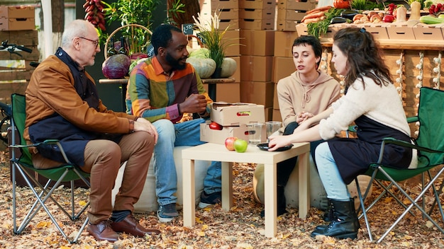 Joyeux groupe d'amis faisant des échantillons de produits sur le marché alimentaire local