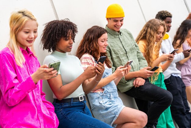 Photo joyeux groupe multiethnique ludique de jeunes amis se liant à l'extérieur