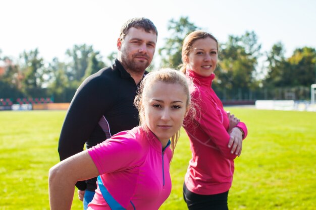 Photo joyeux groupe de sportifs sur le stade avant l'entraînement