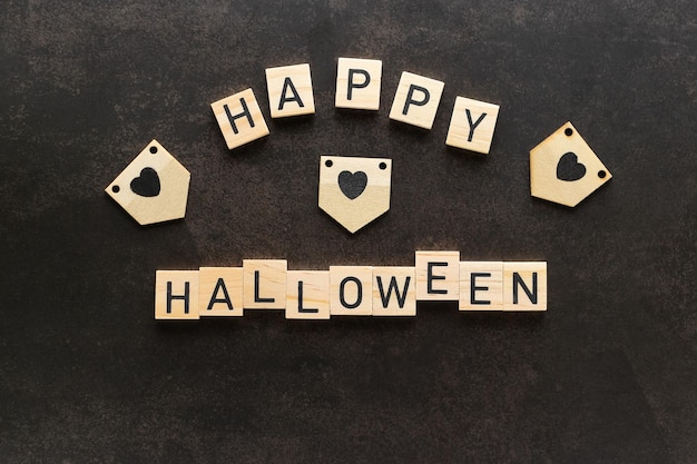 Photo joyeux halloween lettrage en lettres carrées en bois sur fond sombre vue de dessus