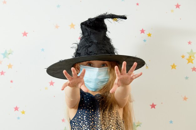 Joyeux Halloween . Petite fille enfant en costume de carnaval de sorcière et masque de protection du visage.