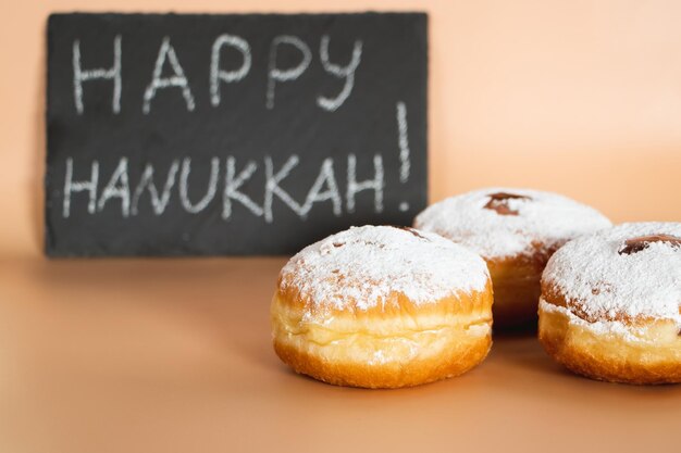 Joyeux Hanukkah dessert juif traditionnel Sufganiyot célébrant la fête du judaïsme Donuts avec de la confiture et du sucre en poudre