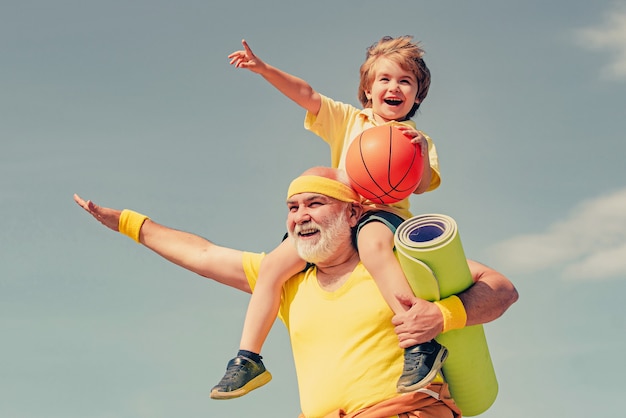 Joyeux homme âgé et mignon petit garçon pratiquant le sport et un mode de vie sain sur le ciel