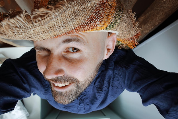 joyeux homme souriant avec une barbe dans un chapeau de paille d'été