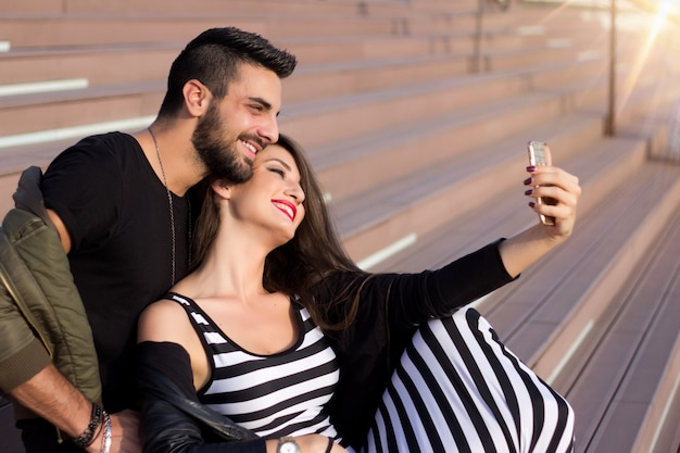 Joyeux jeune couple d'amoureux faisant selfie