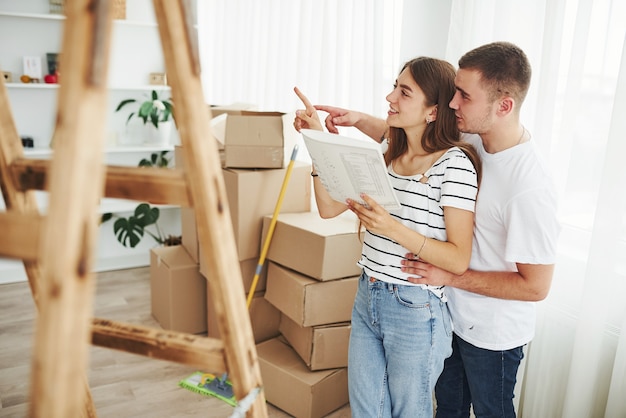 Joyeux jeune couple dans leur nouvel appartement. Conception du déménagement.