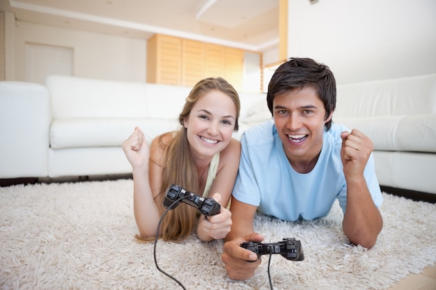 Joyeux jeune couple jouant à des jeux vidéo